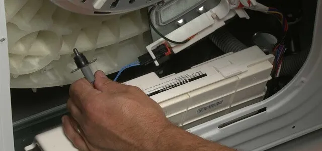 Мастер тестирует датчик температуры в стиральной машине Мастер тестирует датчик температуры в стиральной машине
